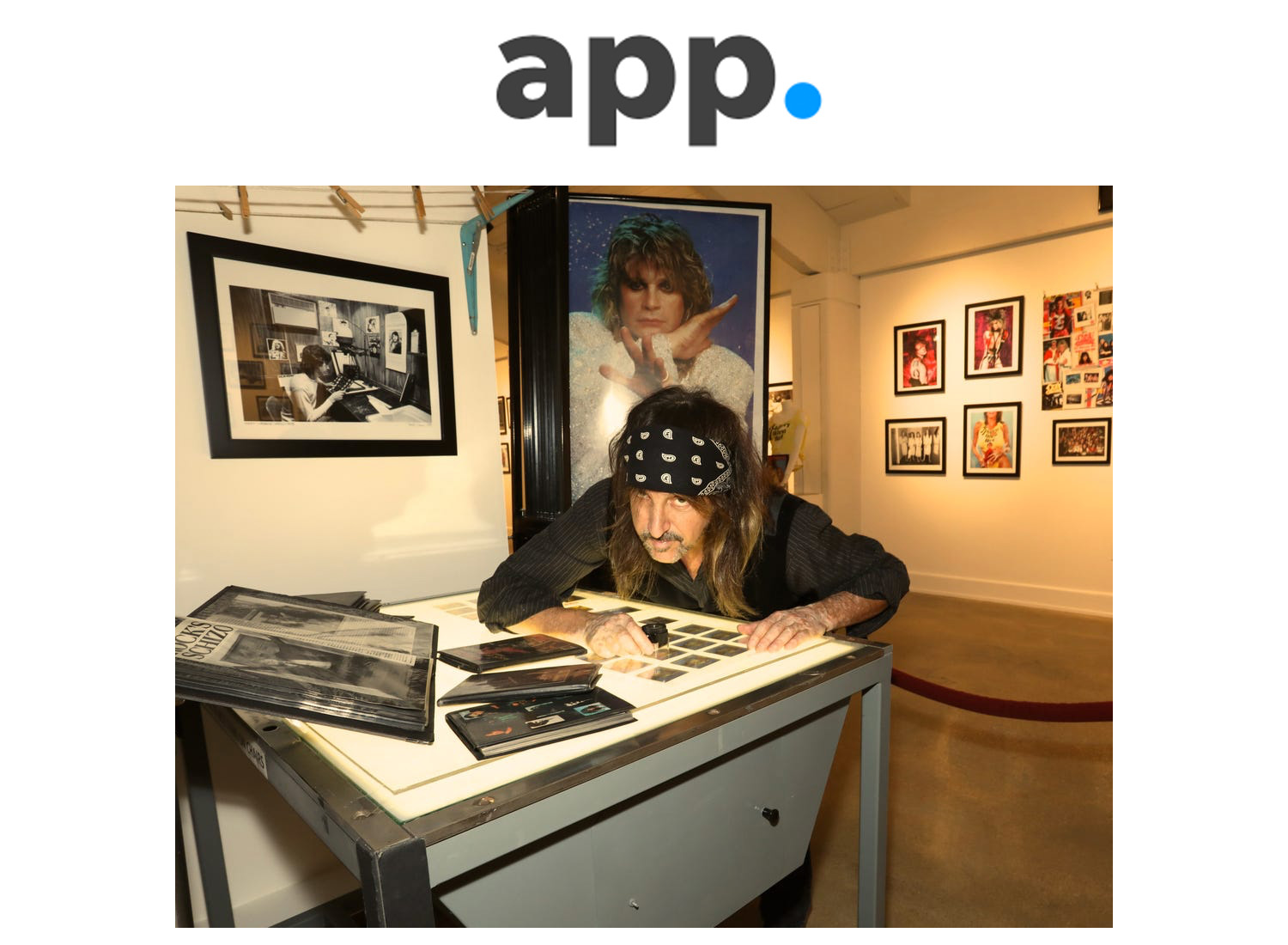 A person sitting at a desk with an app logo on the wall.